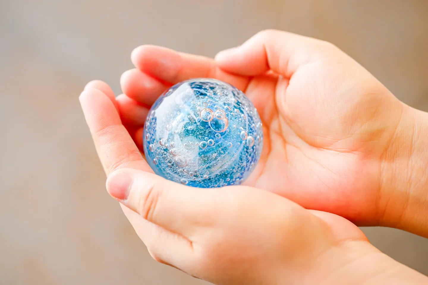 両手の上に大事に乗せられた青く綺麗な商品の写真